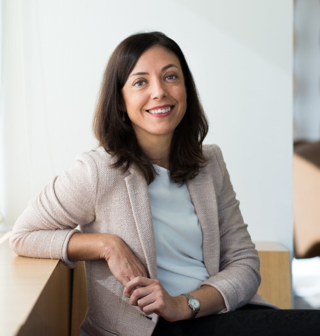 Smiling woman in blazer seated by window in office