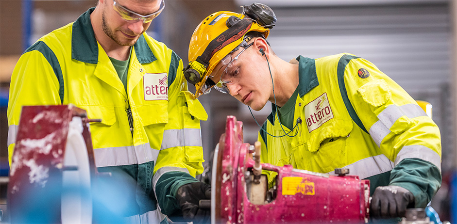 Medewerkers werken aan machine in werkplaats