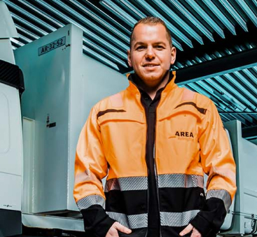 Medewerker in oranje jas bij vrachtwagen