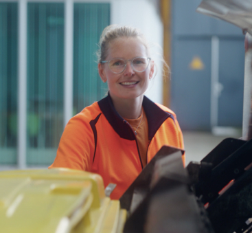 Medewerker in oranje werkkleding op werkplek