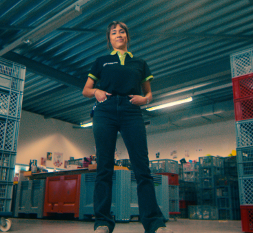Medewerker in magazijn tussen stapelkratten