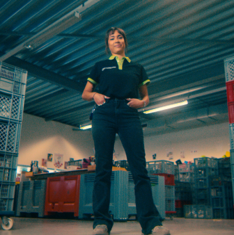 Medewerker in magazijn tussen stapelkratten