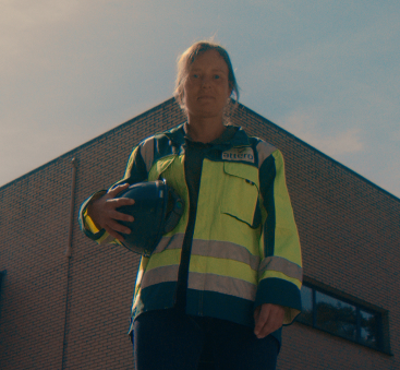 Medewerker met helm voor bedrijfsgebouw