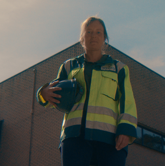 Medewerker met helm voor bedrijfsgebouw