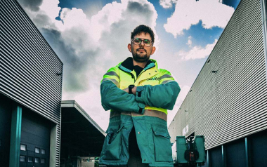 Medewerker in veiligheidskleding voor gebouw