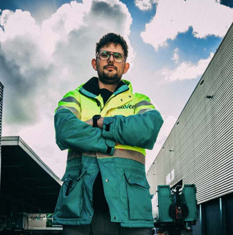 Medewerker in veiligheidskleding voor gebouw