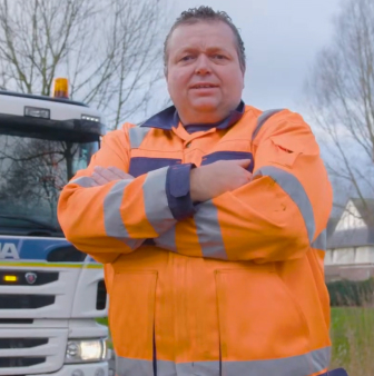 Vuilnisman staat met armen gekruist bij wagen bus!