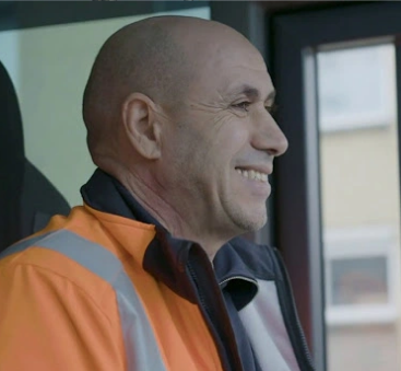 Vuilnisman lacht in cabine van vrachtwagen extra