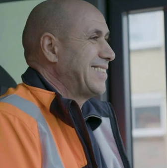 Vuilnisman lacht in cabine van vrachtwagen extra