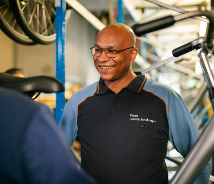 Medewerker in fietsenwerkplaats met rekken.