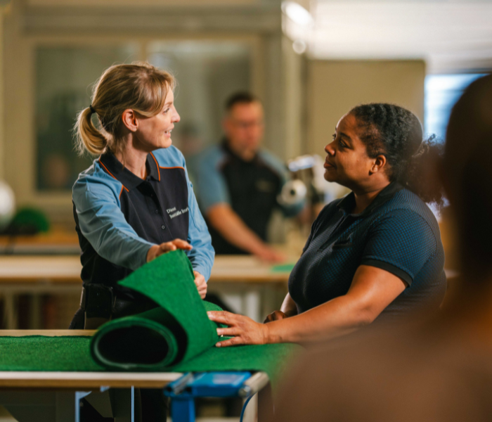 Personen werken samen met groene matten.