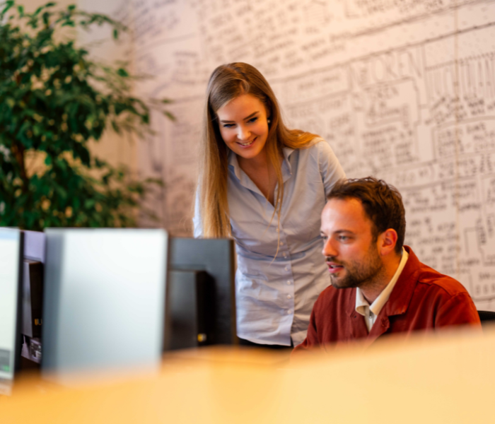 Collega’s werken samen achter computerschermen.