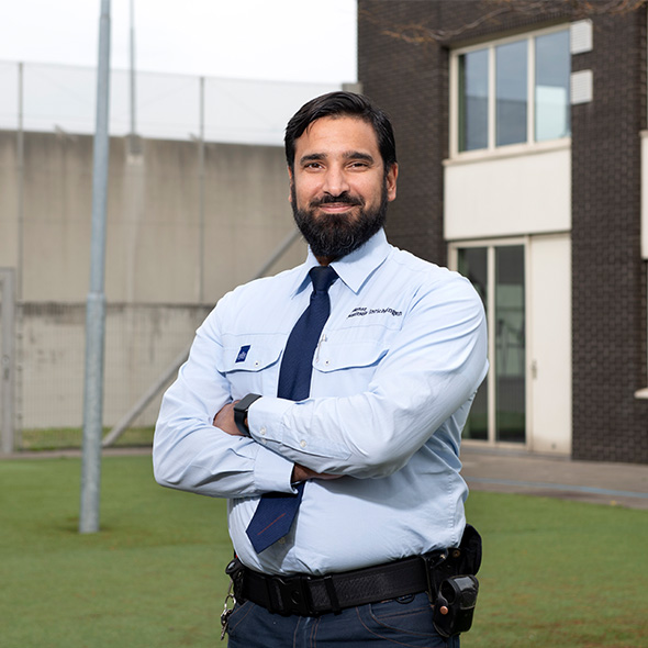 Beveiligingsmedewerker staat in gang bij deur.