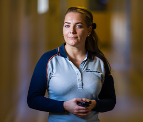 Vrouw in werkkleding kijkt zelfverzekerd