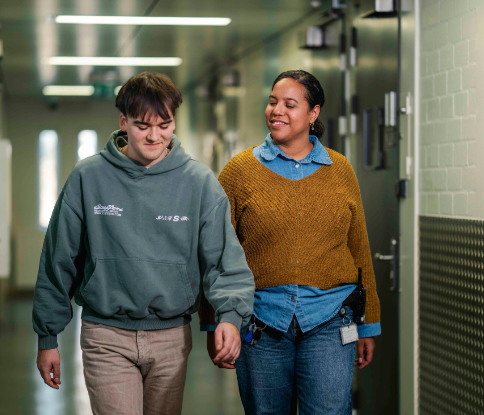 vrouw loopt naast jongen door gang