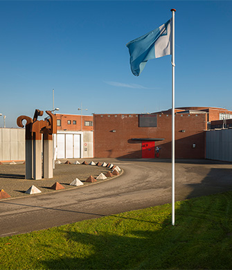 Ingang van gebouw met vlag en kunstwerk