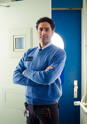 Beveiligingsmedewerker in gang met gekruiste armen