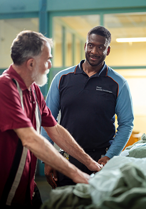 Medewerkers vouwen wasgoed in gevangenisruimte