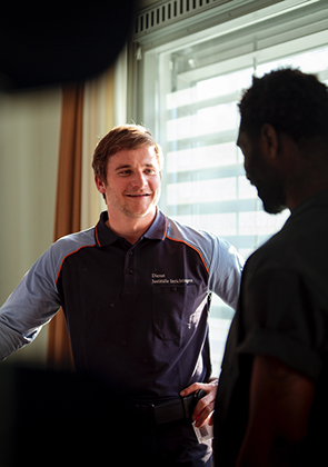 Begeleider praat met man bij raam