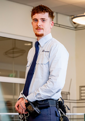 Beveiliger staat binnen met sleutelbos en portofoon