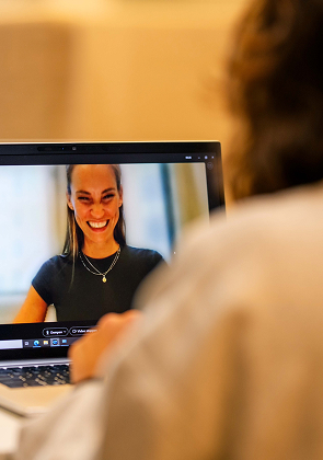 Videogesprek met lachende vrouw op laptop