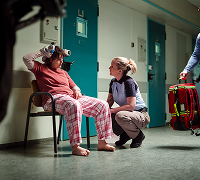 Medewerker helpt zittende persoon