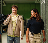 Twee personen lopen samen door een gang