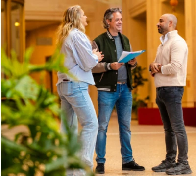 Drie collega’s in gesprek in lichte hal