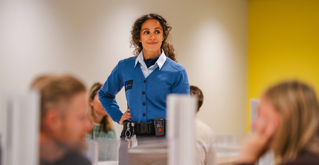 Medewerkster staat in ruimte met collega’s