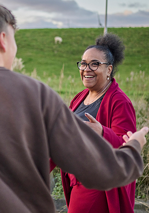 Vrouw praat lachend met man buiten