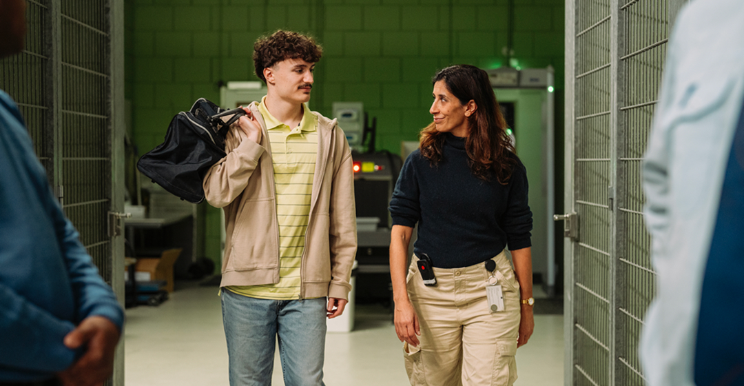 Medewerkster loopt met man door gang