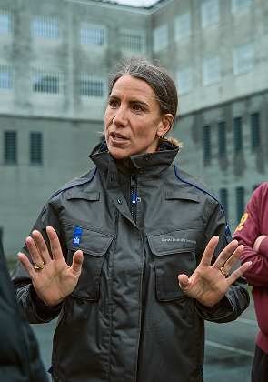 Medewerker spreekt met groep buiten bij gebouw