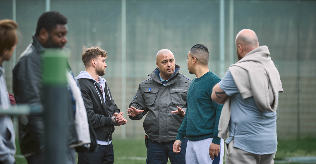 Medewerker spreekt buiten met kleine groep mensen