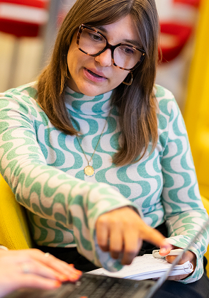 Collega wijst iets aan tijdens samenwerken