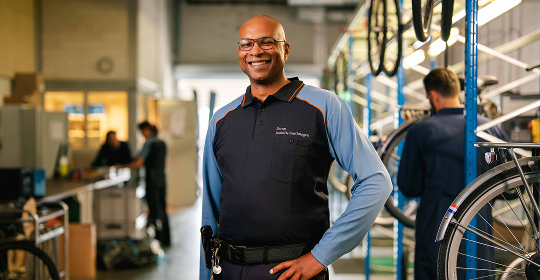 Lachende man in werkplaats met fietsenrek vloer nu