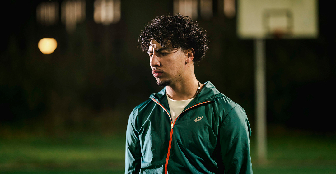 Man in sportjack kijkt nadenkend op veld