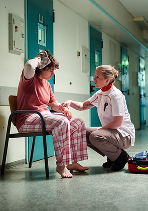 Zorgmedewerker helpt persoon in gang van inrichting