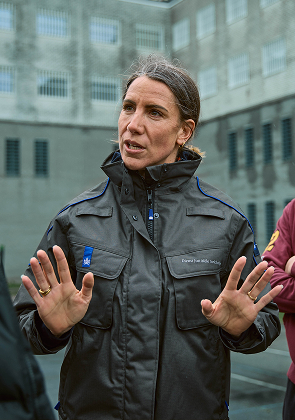Begeleider praat met groep in gevangenisruimte