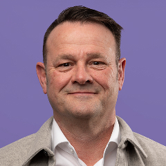 Persoon in lichte jas voor paarse achtergrond