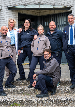 Team medewerkers poseert samen voor het gebouw