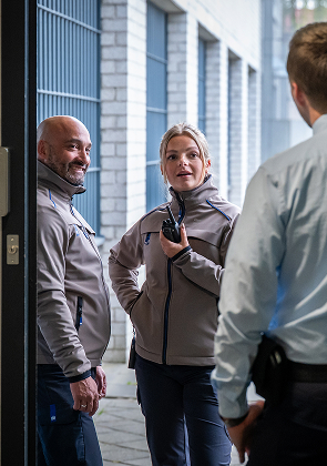 Medewerkers overleggen bij deuropening in gang