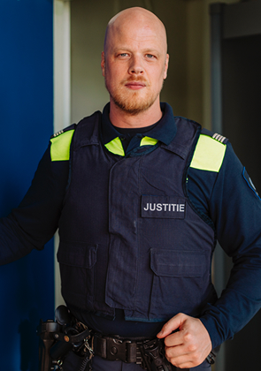 Justitiemedewerker staat bij deuropening