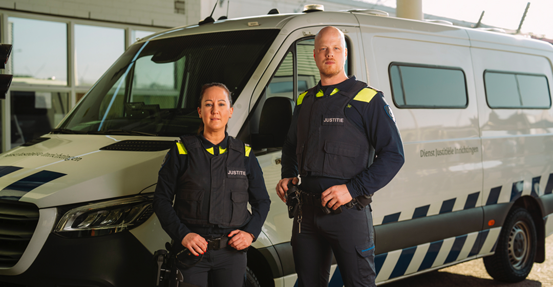 Twee justitiemedewerkers bij dienstbus