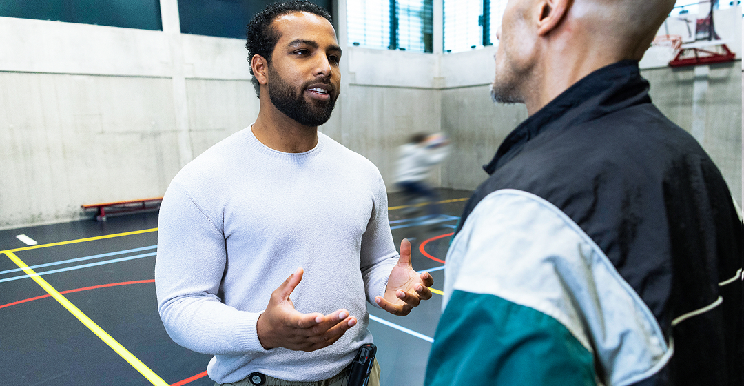 Sportbegeleider in gesprek met deelnemer