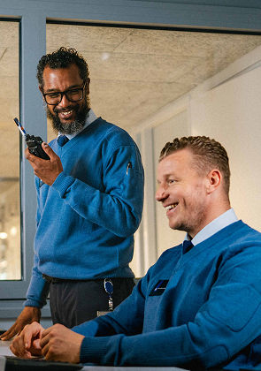 Collega’s lachen samen met portofoon op kantoor binnen