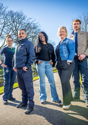 Team collega’s poseert samen buiten in zonlicht