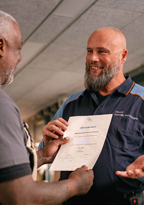 Medewerker overhandigt document aan collega