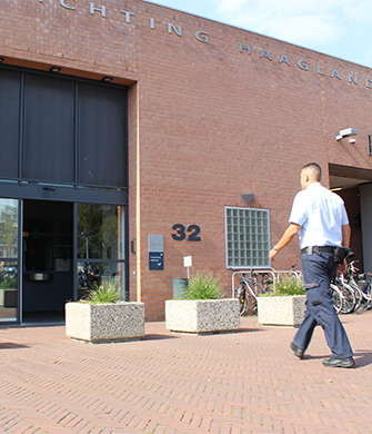 Beveiliger loopt langs ingang van gebouw