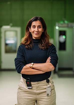 Vrouw met gekruiste armen in industriële werkplaatsruimte