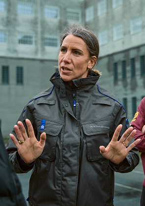 Beveiligingsmedewerkster geeft instructies aan groep mensen